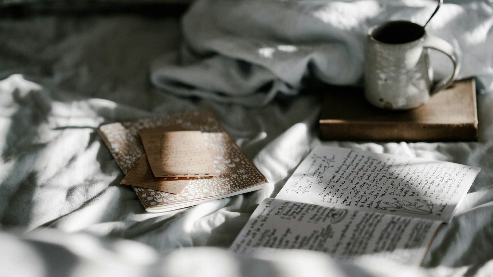A notebook and a cup of coffee in morning light